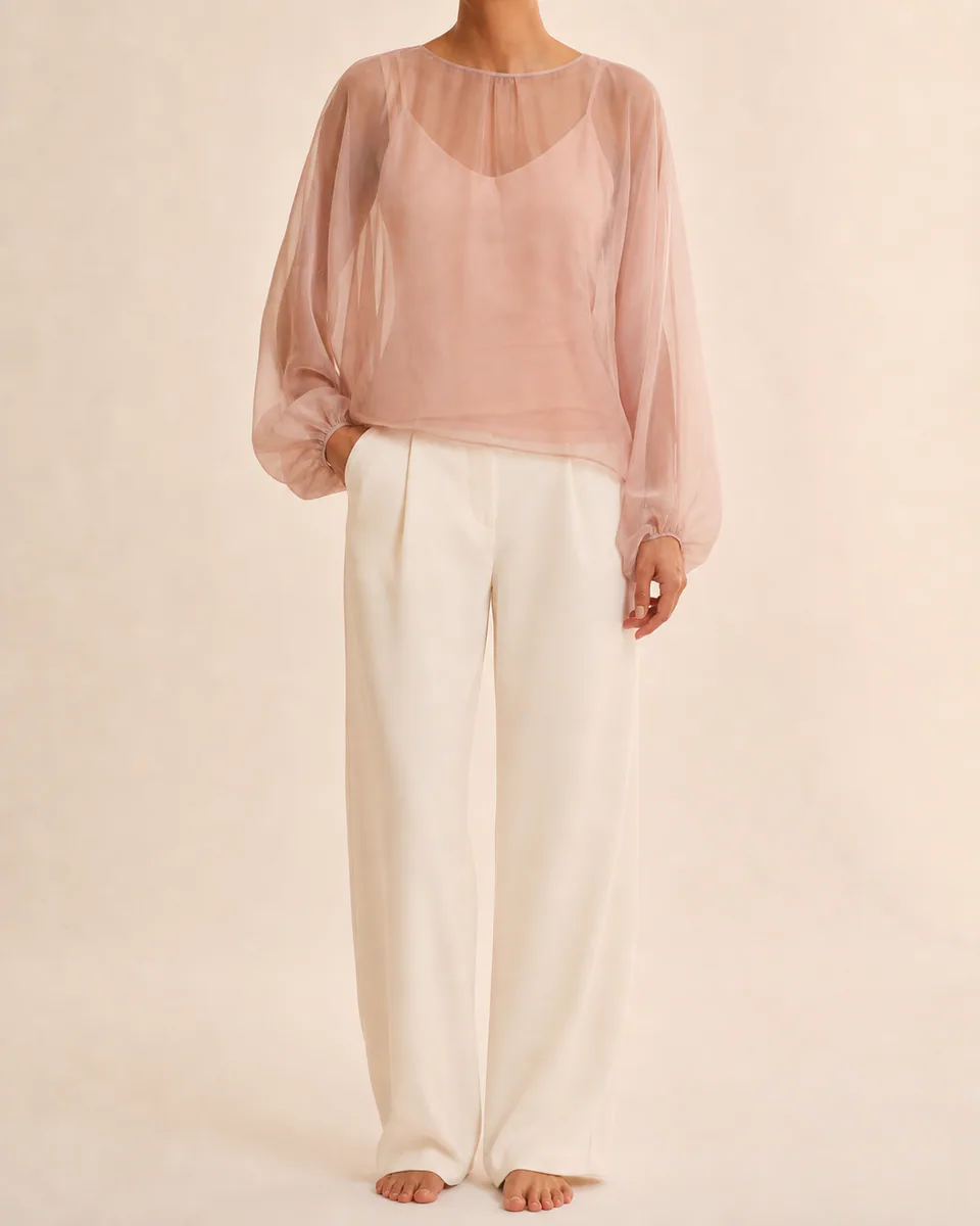 Modelo vestindo blusa blush de organza com mangas delicadas em estúdio claro