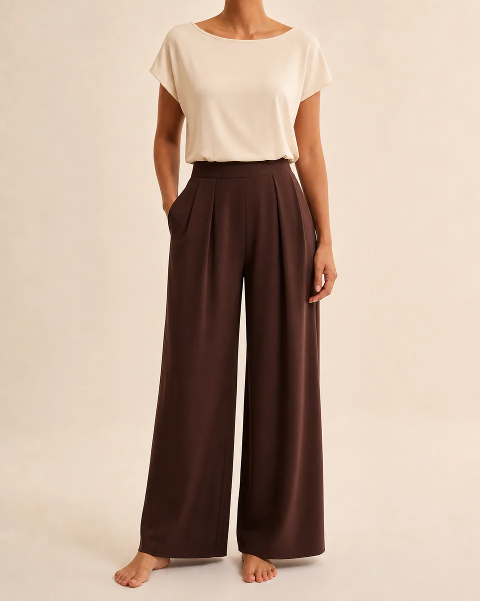 Modelo vestindo calça pantalona chocolate de cintura alta em estúdio claro
